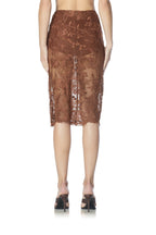 Back view of a woman wearing a knee-length cappuccino lace skirt paired with high-heeled shoes.