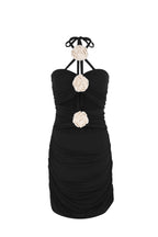 Black mini dress with halter neck and three white crochet rose cutout details, ruched fabric design.