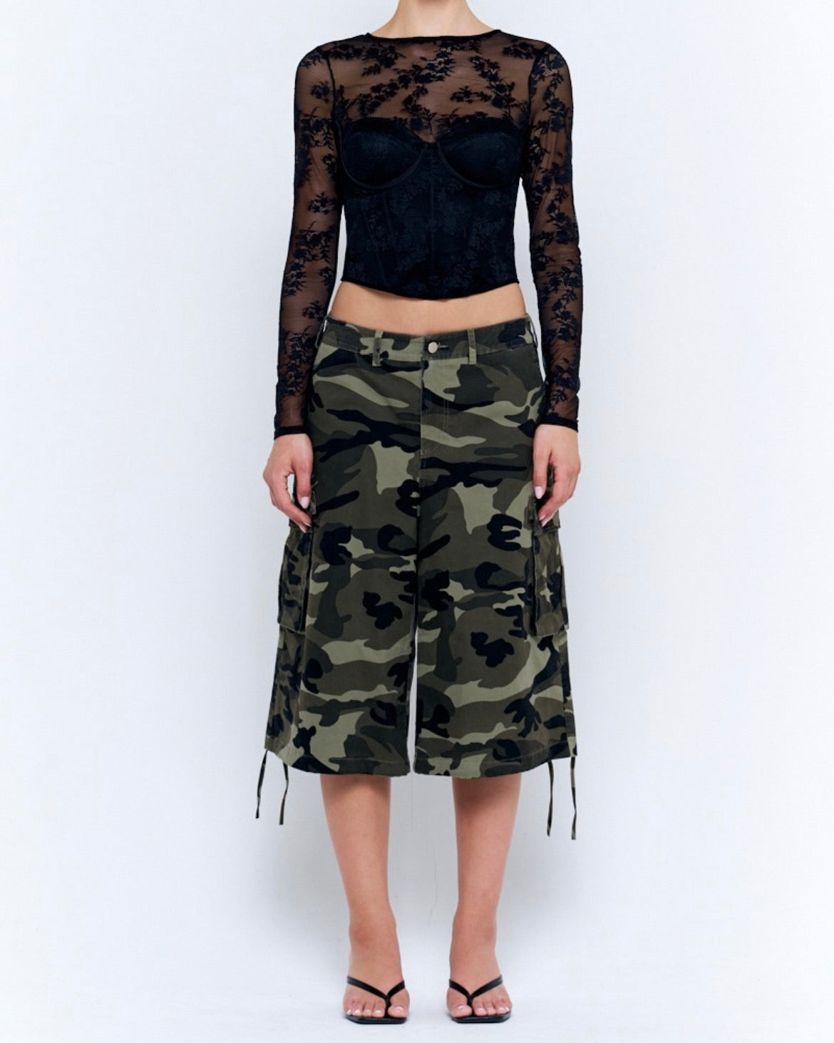 Woman wearing camouflage wide leg cargo culotte pants with drawstring hems and a black lace top