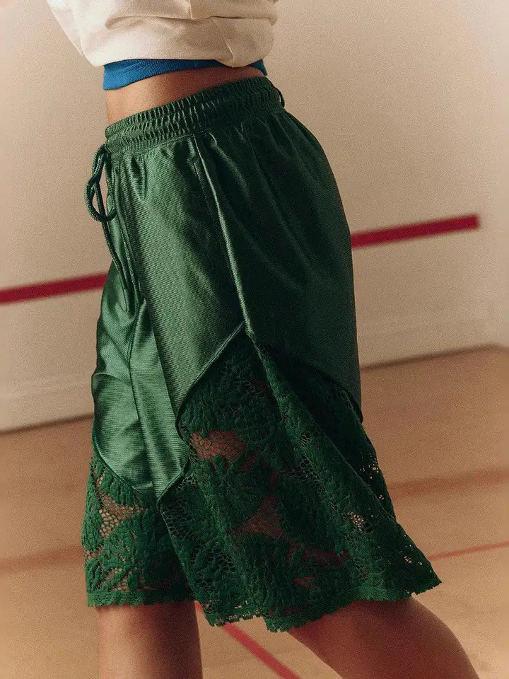 Green satin shorts with floral lace panels and a scalloped hem