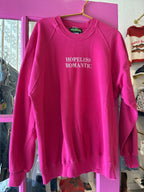 Bright pink sweatshirt for women with "HOPELESS ROMANTIC" embroidered text on the front, casual style clothing.