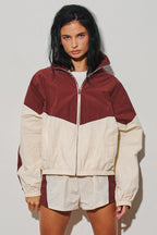 Womens burgundy and cream colorblock hooded zip jacket shown on a model