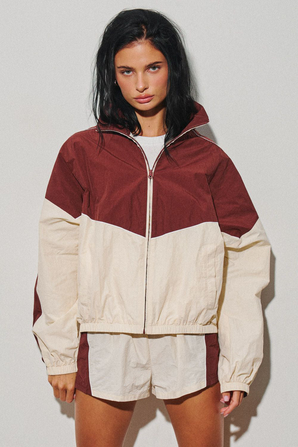 Womens burgundy and cream colorblock hooded zip jacket shown on a model