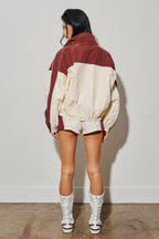 Woman modeling colorblock windbreaker shorts with white boots