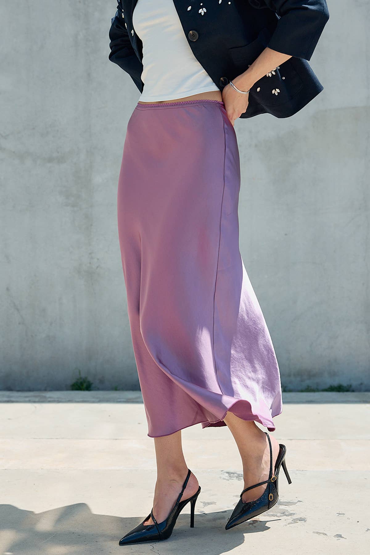 Mauve satin midi skirt styled with black heels and a dark jacket