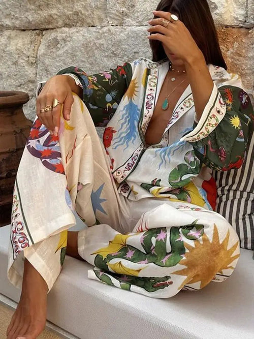 Woman wearing colorful abstract patterned pants and matching shirt sitting on a cushion outdoors