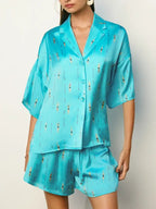 Woman wearing a loose turquoise lounge top and matching shorts with small swimmer print for casual wear