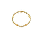 Gold stretch bracelet with small round beads and four larger textured barrel-shaped beads for women’s fashion accessory