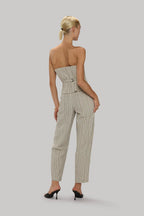 Woman wearing tailored striped trousers with a fitted waist and high-heeled shoes in a neutral tone