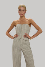 Woman wearing a striped, tailored women's outfit with breathable fabric, hands on hips against a neutral background