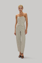 Woman wearing tailored striped trousers and a matching fitted strapless top in neutral tones