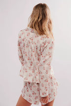 Woman wearing a floral long-sleeve button-down shirt and matching shorts women's sleepwear set from behind