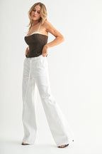 Woman wearing high-rise wide-leg white denim pants with a detachable belt styled with a dark strapless top