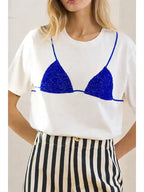 Woman wearing white tee with blue bikini graphic paired with high-waisted black and white striped pants in women's clothing style