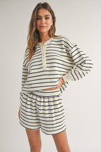 Woman wearing cream and black striped long sleeve top and matching shorts in casual women's clothing