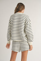 Woman wearing a white and black striped long-sleeve top with matching shorts in casual women's clothing style