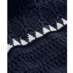 Close-up of textured navy blue knit fabric with white striped detail on women's clothing material.