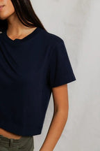 Woman wearing a navy blue cropped tee with short sleeves, styled casually with olive green pants