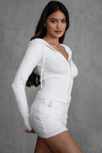 Woman wearing a stylish white knit mini skort with silver hardware and a matching zip-up hoodie in women's clothing.