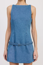 Woman wearing sleeveless fitted denim mini dress with belt detail at waist, styled for women's clothing.