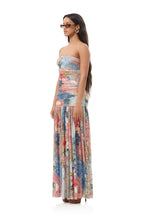 Woman wearing a strapless, colorful patchwork maxi dress styled with sunglasses and gold hoop earrings.