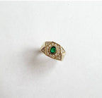 Gold hexagon ring with emerald center stone and surrounding diamonds, elegant women's fashion jewelry accessory