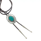 Western-style bolo tie with turquoise stone and silver-tone decorative tips on black leather cords