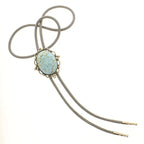 Gray cord bolo tie with an oval floral stone centerpiece and metal tips for women's fashion accessories.