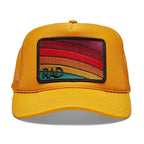 Yellow trucker hat with colorful retro stripes and "RAD" embroidered patch on front panel for women's apparel.