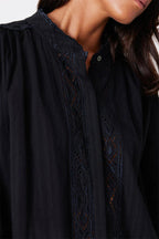 Close-up of women's black soft cotton shirt with intricate handcrafted embroidery and scallop neck detail