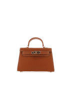 Brown leather handbag with top handle and gold-tone hardware, designed for women's fashion and style.