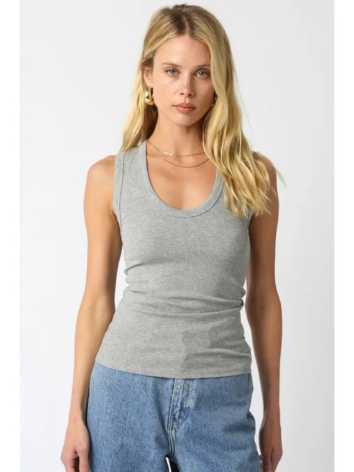 Woman wearing a gray ribbed tank top with scoop neckline and jeans