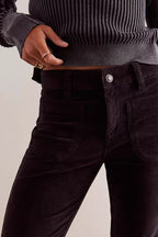 Close-up of women's high-rise black corduroy pants with kick flare silhouette and front patch pockets