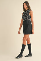 Woman wearing sleeveless black mini dress with sequins and collar, paired with knee-high socks and black shoes