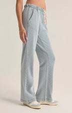 Woman wearing light blue knit denim pants with a drawcord waistband and side pockets in casual style.