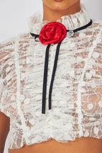White lace crop top with ruched detailing and red rosette accent on neckline, women's clothing