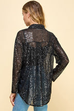 Back view of a woman wearing a loose fit black sequin button-up top with long sleeves and collar