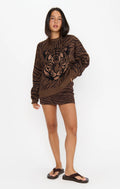 Woman modeling a brown tiger print sweater with long sleeves and black sandals