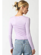 Woman wearing a fitted lilac ribbed long sleeve top paired with light blue denim jeans from the back view