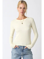Woman wearing an ivory ribbed long sleeve top styled with light blue denim jeans and gold necklaces