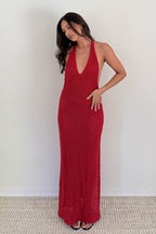 Woman wearing a red knitted halter maxi dress with a plunging neckline and side slits in women's clothing.
