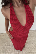 Close-up of a woman wearing a red knit halter maxi dress with a plunging neckline and open back in women's clothing.