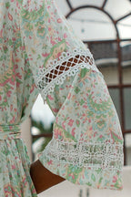 Close-up of bohemian style women's dress sleeve with floral print and decorative lace details