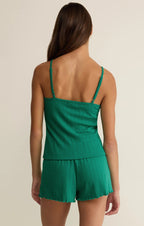 Woman wearing a green ribbed camisole and matching shorts, back view, casual women's clothing.