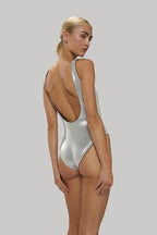 Woman wearing a low-back metallic silver bodysuit with sleek, modern design in women's clothing fashion.
