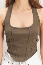 Close-up of a woman wearing a fitted sleeveless halter top with a mineral wash pattern in brown tones.