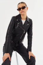 Woman wearing a fitted black leather moto jacket with diagonal zipper and sunglasses in a fashion pose