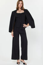Woman wearing stylish black seamed wide-leg pants with a matching black blazer and sleeveless top in women's clothing.
