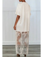 Woman wearing white maxi shirt dress with sheer lace skirt detail standing indoors