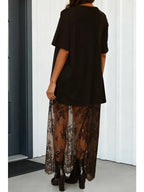 Woman wearing black lace maxi shirt dress with sheer floral skirt and black ankle boots viewed from behind